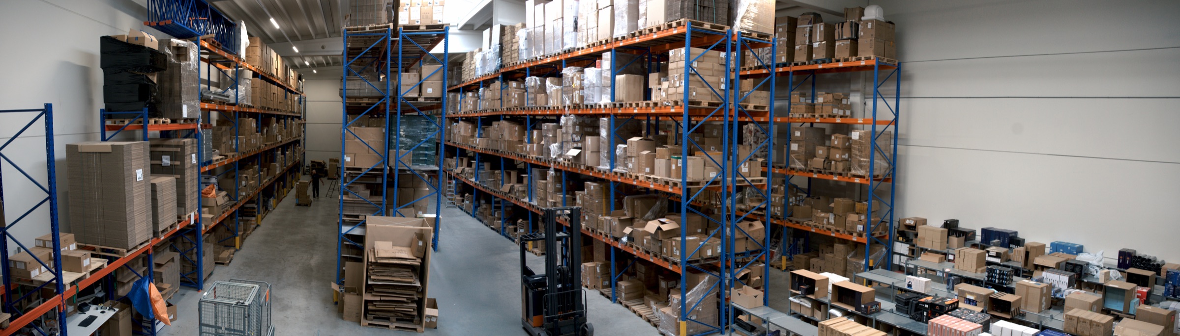 Panorama van het warehouse van RTM Fulfilment in Rotterdam met blauwe pallet-racks, reachtruck en paktafels